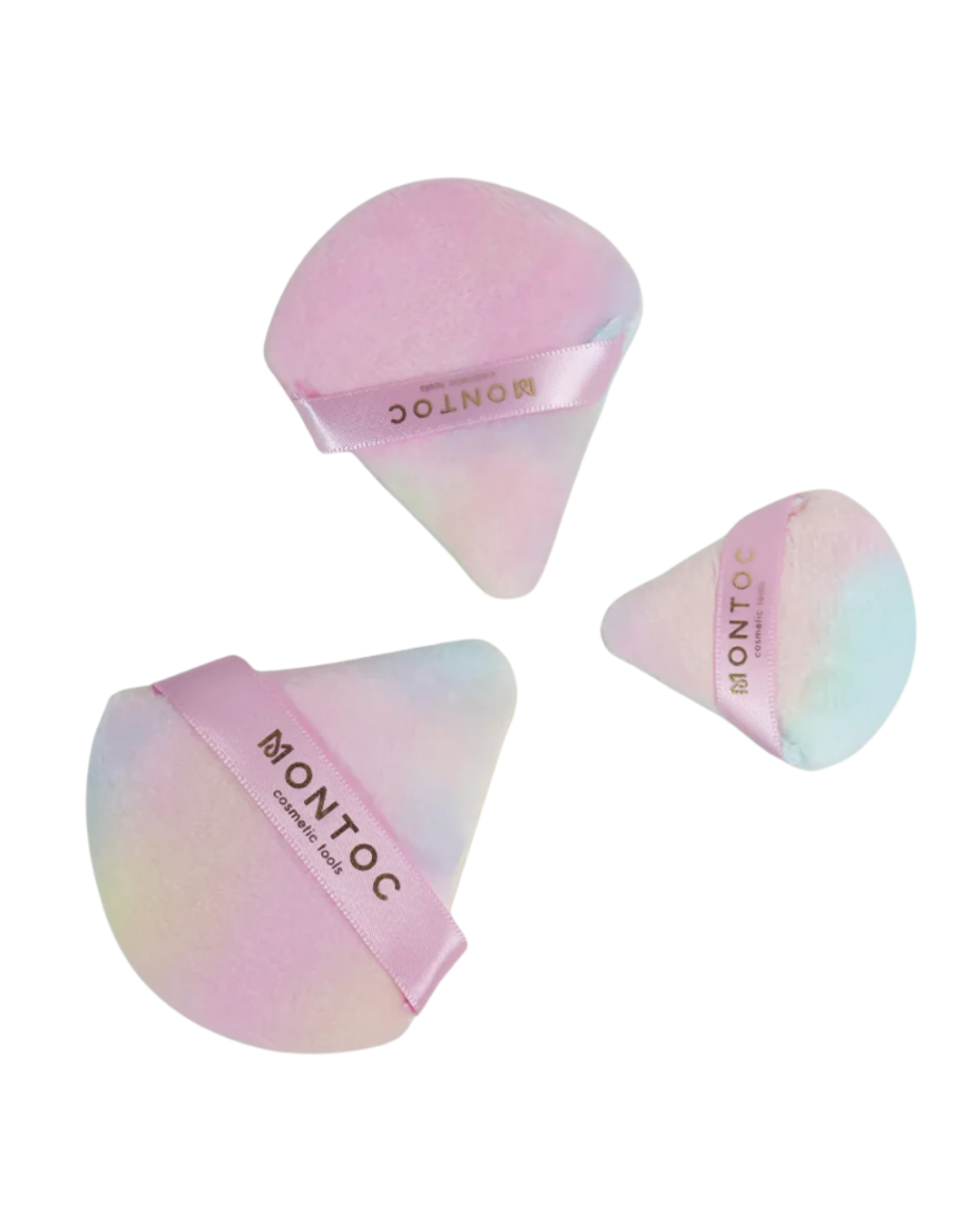 Tres borlas triangulares de maquillaje con acabado tornasolado en tonos pastel rosa y azul, con banda de la marca Montoc sobre fondo blanco.