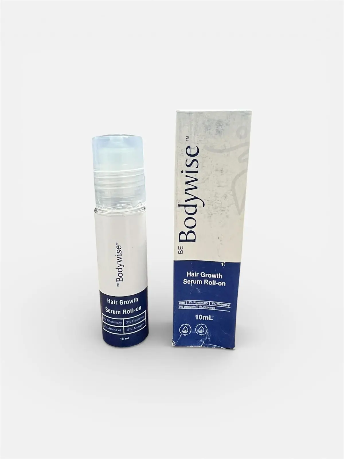 Roll-on Bodywise Hair Growth Serum de 10 ml con tapa transparente y su caja blanca y azul, mostrados de frente sobre fondo blanco.