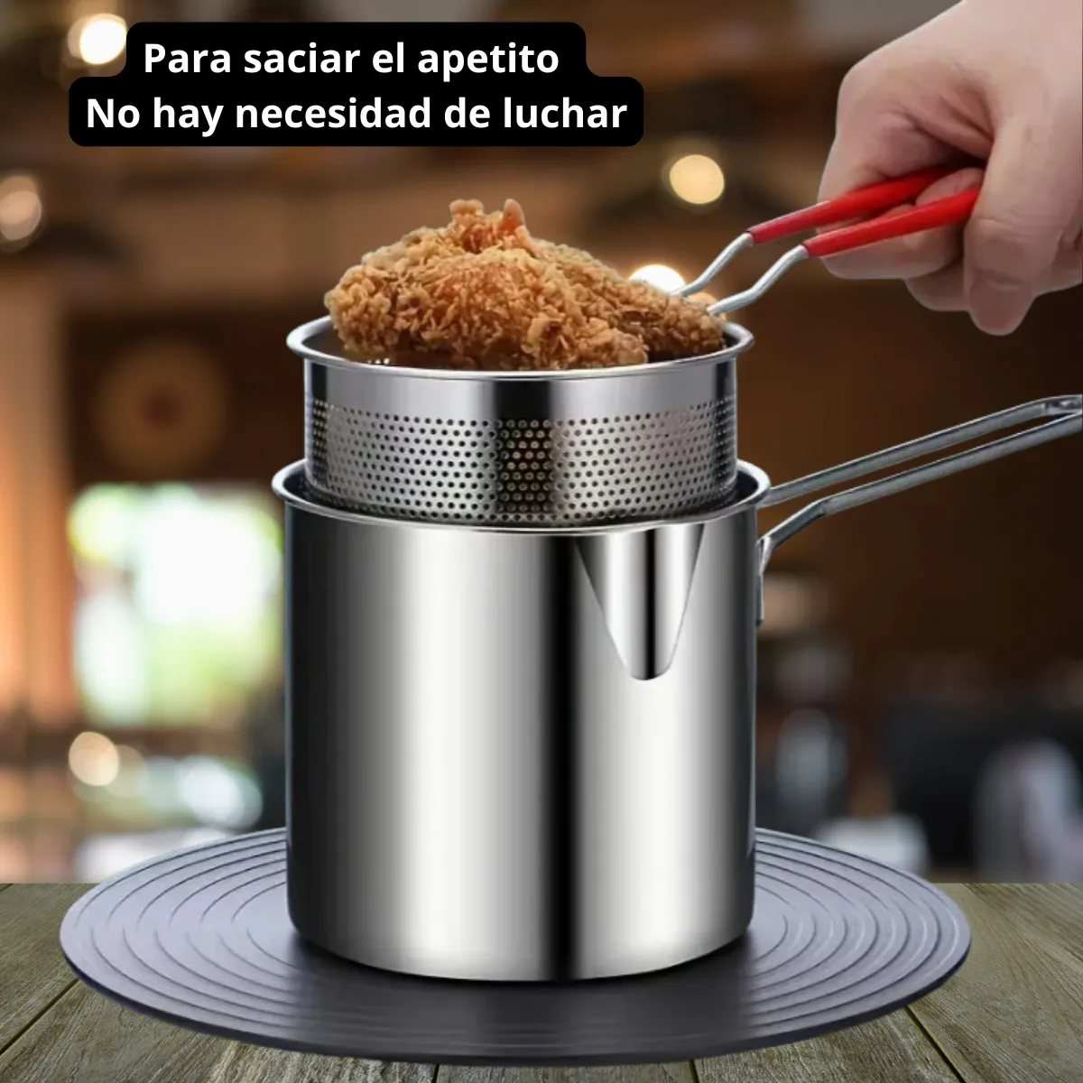 Olla freidora individual de acero inoxidable brillante con cesta escurridora, pico vertedor y piezas con pollo frito dorado.
