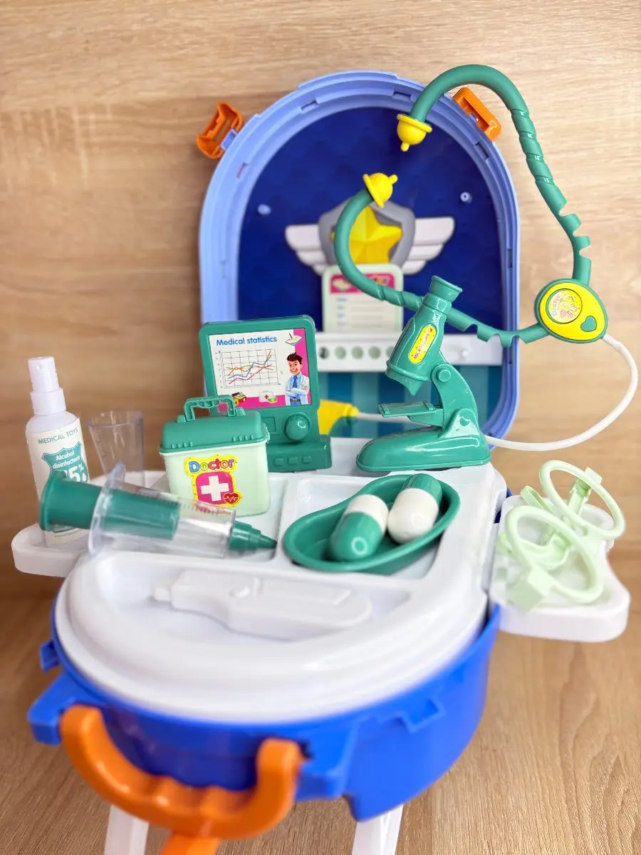 Maleta de doctor portátil azul con accesorios médicos de juguete, estetoscopio verde, microscopio, jeringa, pastillas y caja de primeros auxilios.