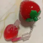 Bálsamo labial hidratante con brillo rojo intenso en frasco con forma de fresa y llavero incluido.