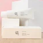 Tubo y caja de protector solar Beauty of Joseon Relief Sun con arroz y probióticos, SPF50+ PA++++, sobre bloques blancos en superficie de madera.