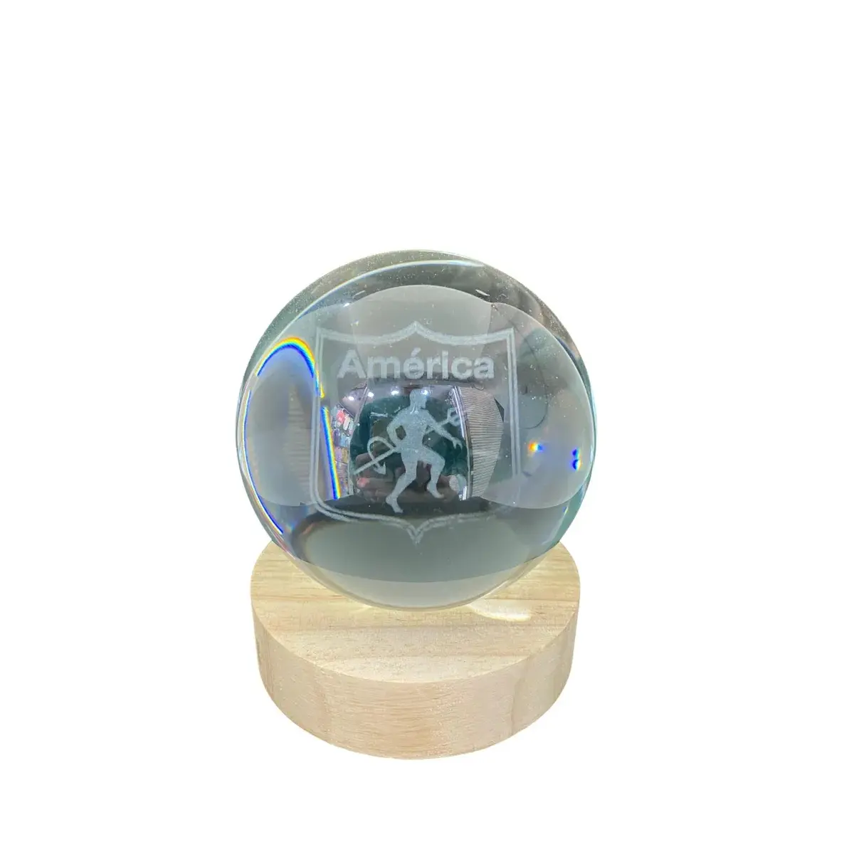 Lámpara de cristal con grabado láser 3D del escudo y nombre América, sobre una base de madera clara.