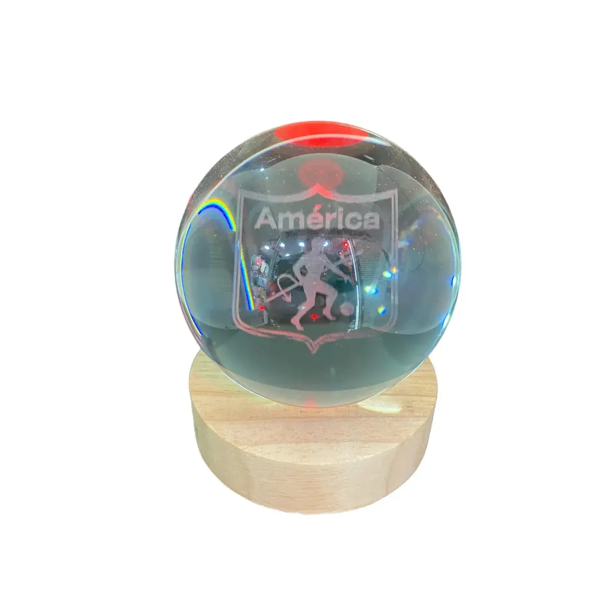 Esfera de cristal con grabado láser del escudo del América de Cali, montada sobre base circular de madera clara con iluminación LED integrada.