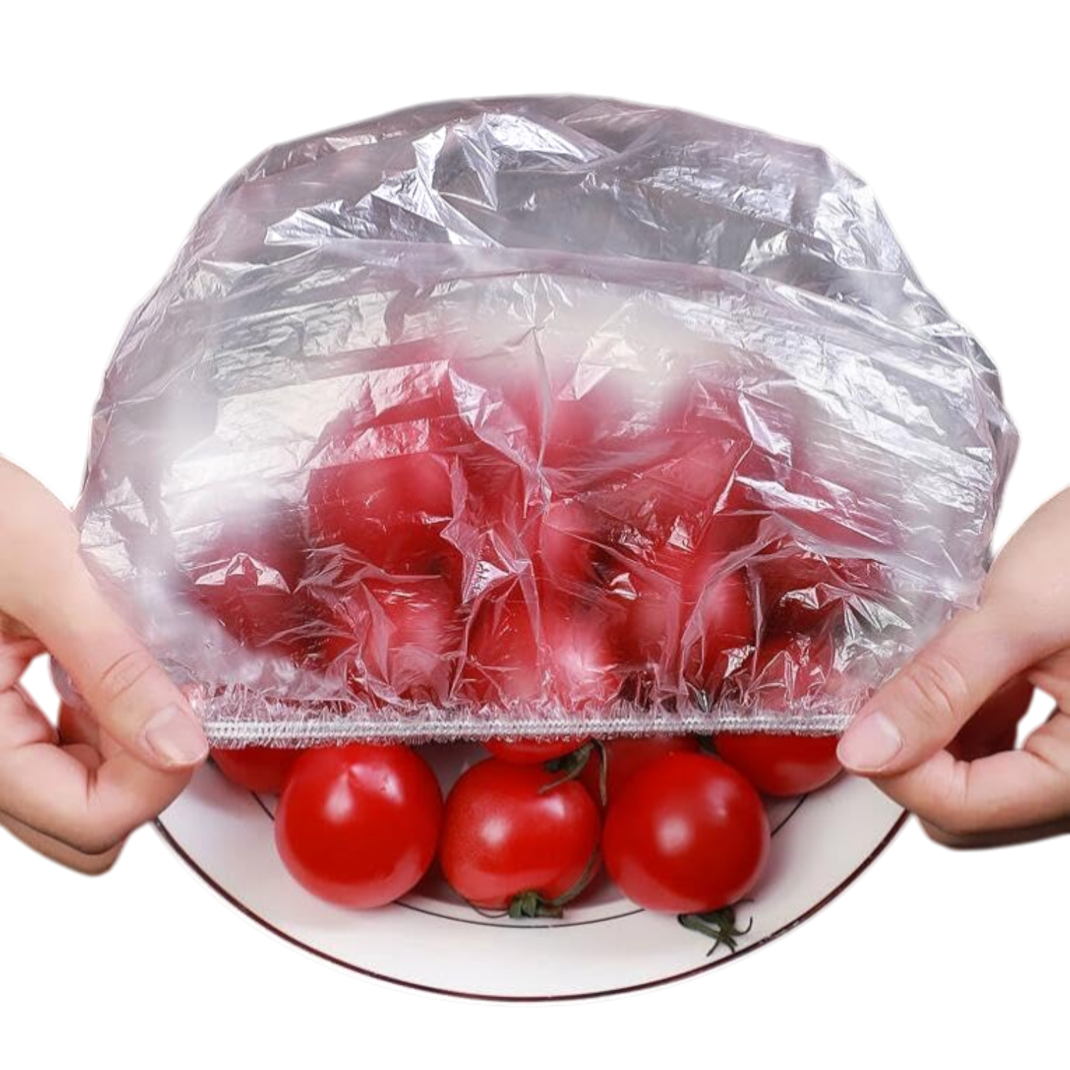 Manos estirando una tapa elástica transparente sobre un plato con tomates rojos, demostrando su función para conservar alimentos frescos.