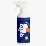 Botella blanca con atomizador y etiqueta azul de 500 ml para quitar manchas en ropa con diseño de camiseta blanca.