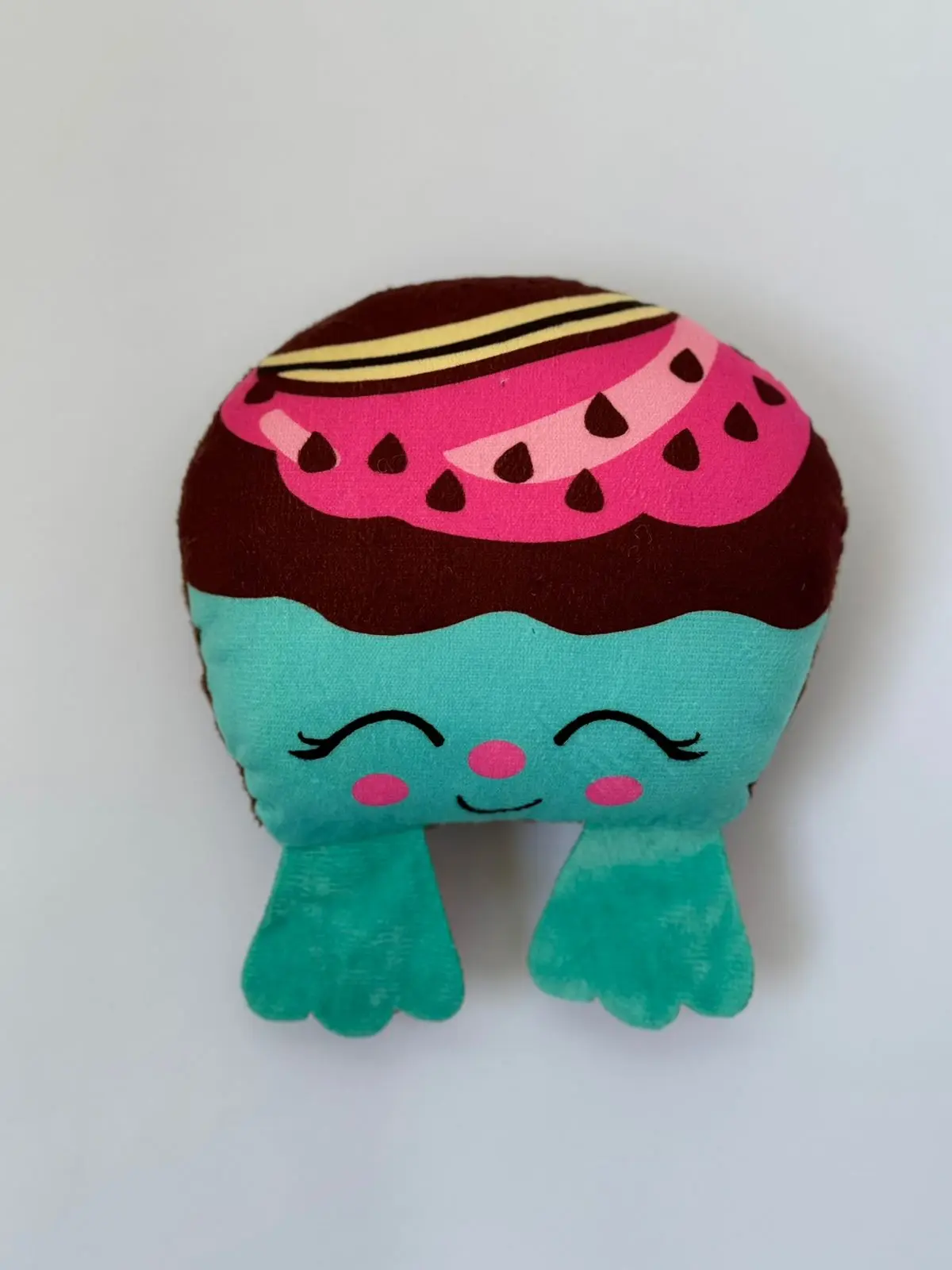 Juguete de peluche Moofie con patrón de sandía rosa y marrón, cuerpo turquesa con rostro sonriente y ojos cerrados.