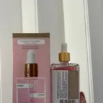 Aceite corporal rosado Soft Serve en frasco con gotero junto a su caja rosa con notas de fresa, vainilla y ámbar.