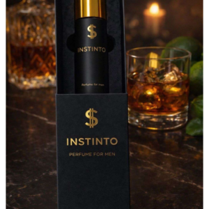 Perfume masculino Instinto en frasco negro con tapa dorada y logo de dólar, presentado en caja negra sobre mesa de mármol junto a un vaso de whisky.