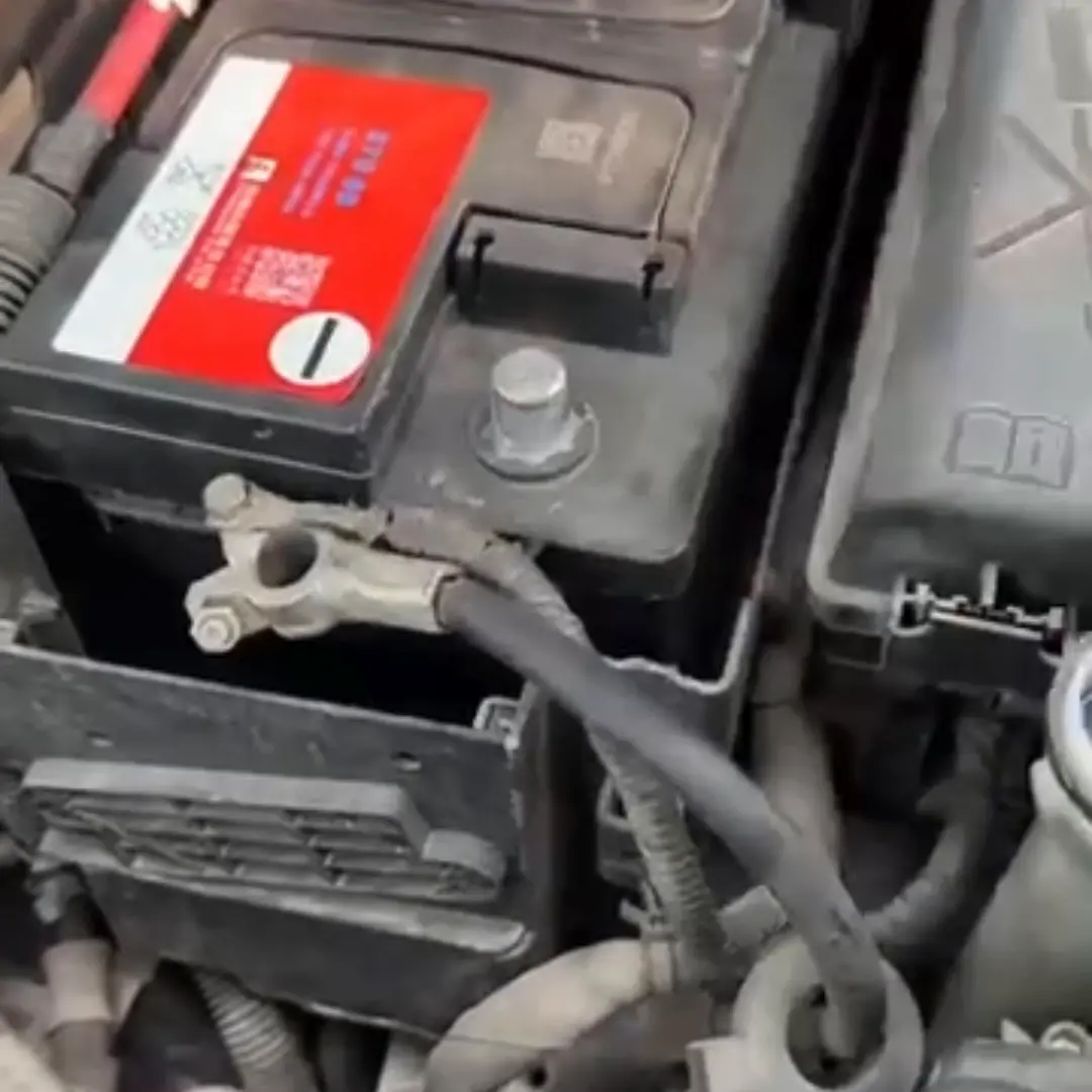 Borne de batería para carro negro con interruptor giratorio metálico instalado en el compartimento del motor.