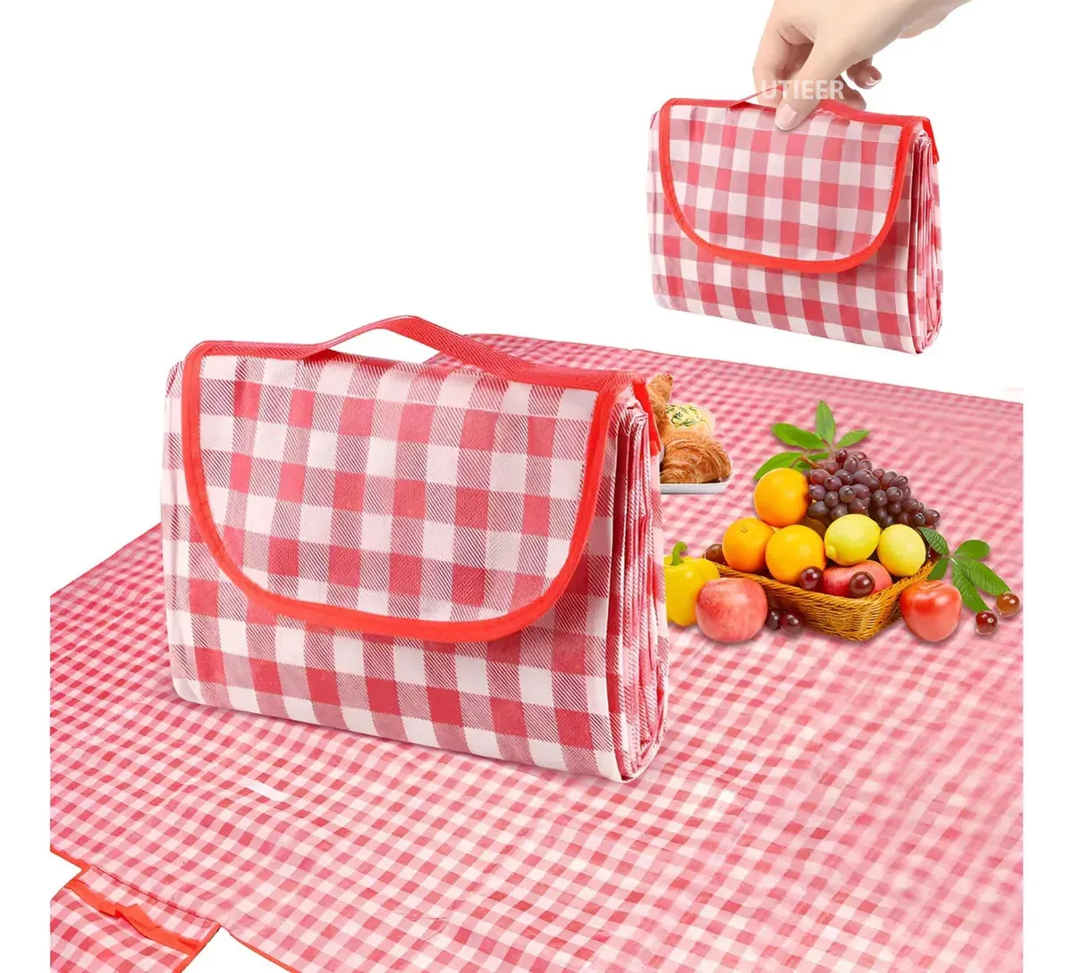 Alfombra de picnic roja a cuadros blancos, impermeable, plegable con asa de transporte y canasta de frutas al lado.