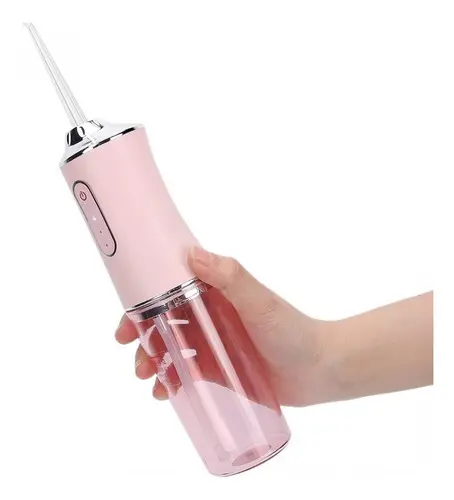 Irrigador bucal recargable color rosa con depósito transparente, sostenido por una mano para mostrar su tamaño y diseño ergonómico.