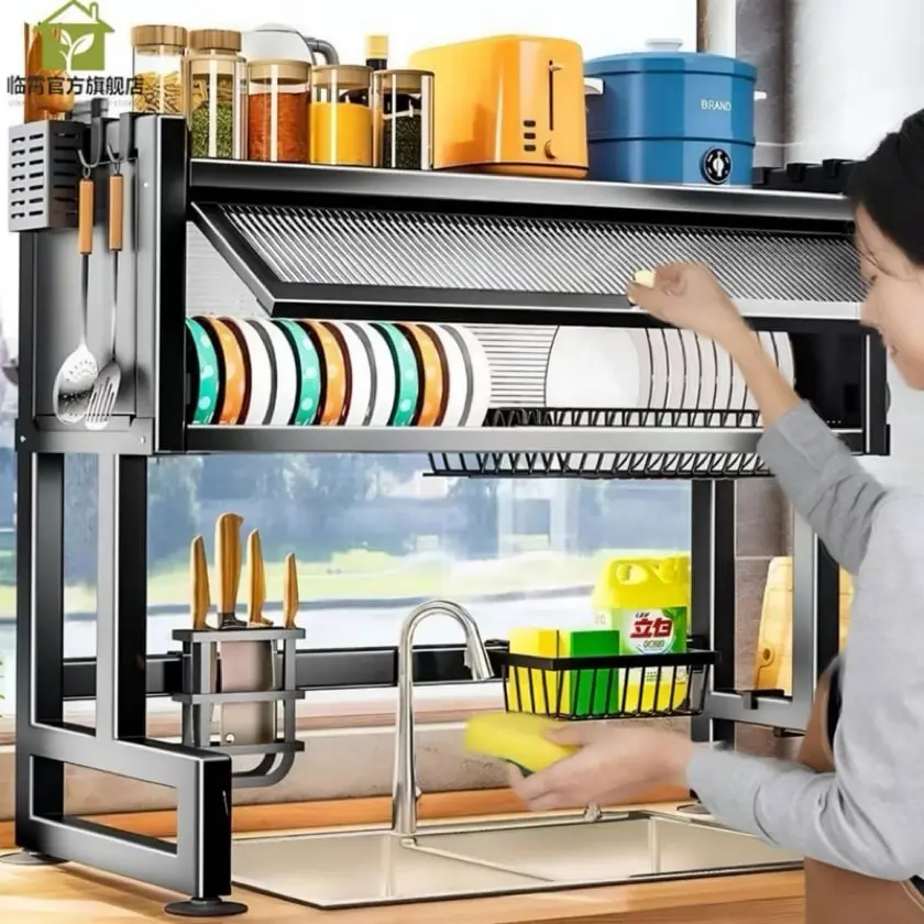 Escurridor de loza negro sobre fregadero con estantes para platos, porta cuchillos, ganchos para utensilios y repisa superior para especias.