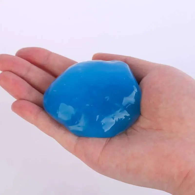 Gel limpiador adhesivo azul brillante para teclados y rendijas, moldeable y reutilizable, sobre la palma de una mano.