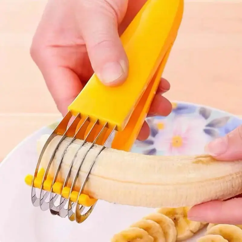 Rebanador de banano con mango amarillo y cuchillas de acero inoxidable cortando un banano en rodajas uniformes sobre un plato.