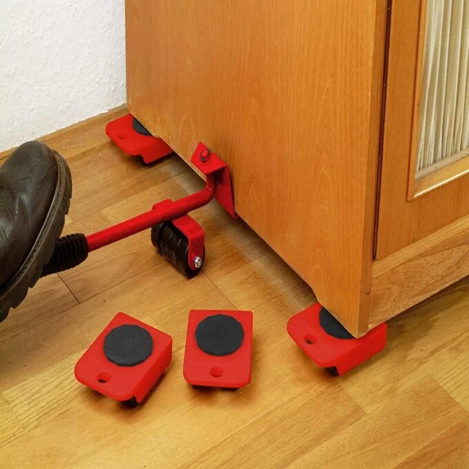 Set rojo para levantar y mover muebles pesados, con palanca deslizante y base con ruedas sobre piso de madera.
