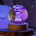 Lámpara LED 3D esfera de cristal con diseño de oso y mensaje "Smile Day", sobre base de madera iluminada en luz morada.