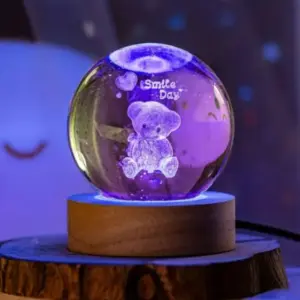 Lámpara LED 3D esfera de cristal con diseño de oso y mensaje "Smile Day", sobre base de madera iluminada en luz morada.