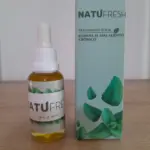 Frasco gotero de 30 ml con líquido ámbar y caja azul de Natufresh, tratamiento bucal contra el mal aliento con diseño de hojas de menta.