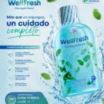 Enjuague bucal WellFresh azul con extractos de menta y eucalipto, rodeado de salpicaduras de agua y hojas verdes naturales.
