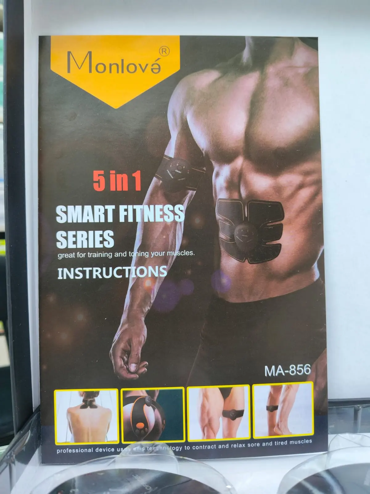Manual impreso de instrucciones para gimnasio EMS 5 en 1 Monlové MA-856, con de hombre usando parches tonificantes.