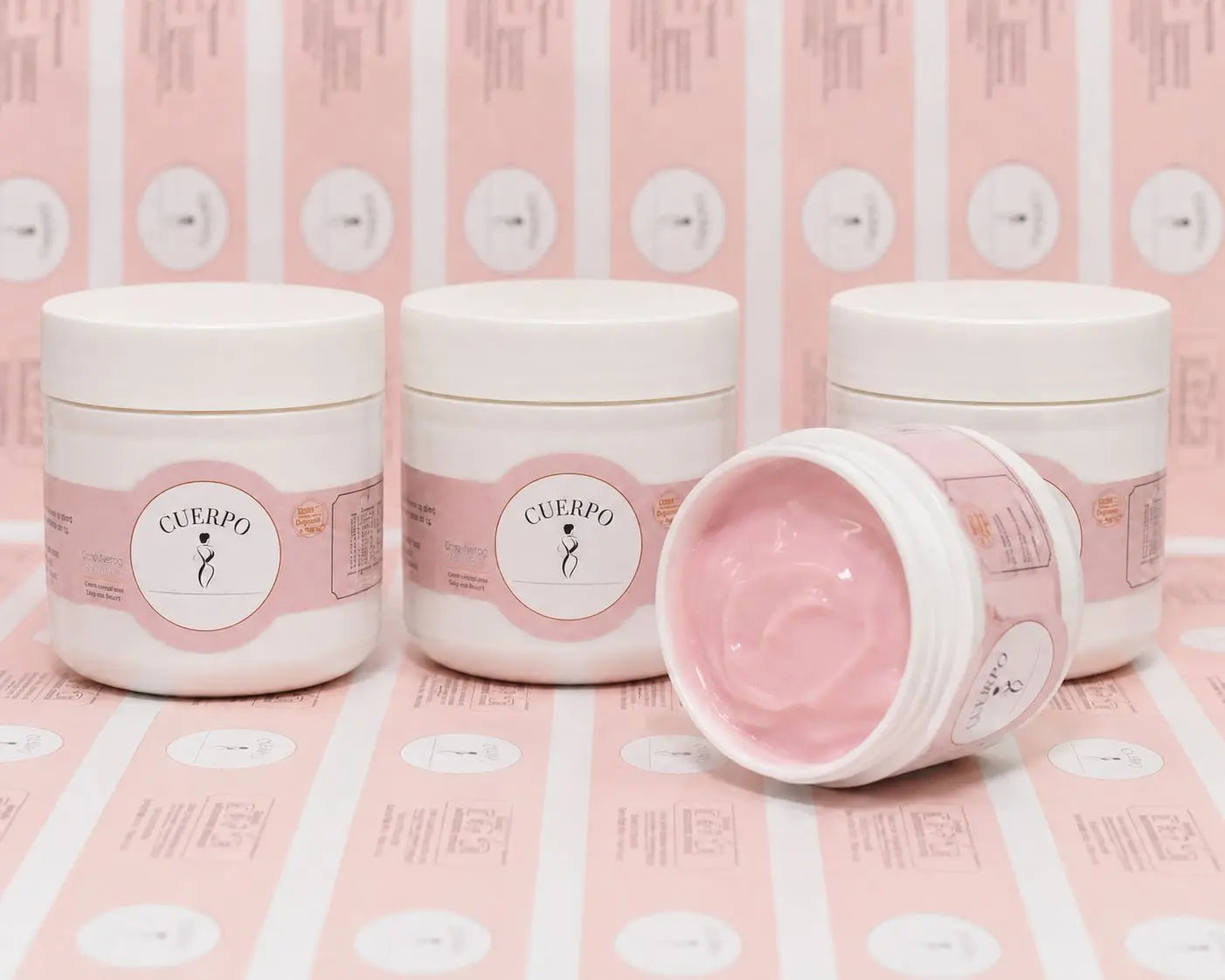 Tres frascos blancos de gel reductor Cuerpo con etiquetas rosas y un envase abierto mostrando su textura cremosa de color rosa.