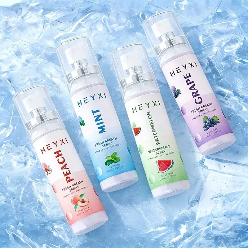 Cuatro atomizadores de spray bucal Heyxi con sabores a durazno, menta, sandía y uva, dispuestos sobre una superficie de hielo azul con textura cristalina.