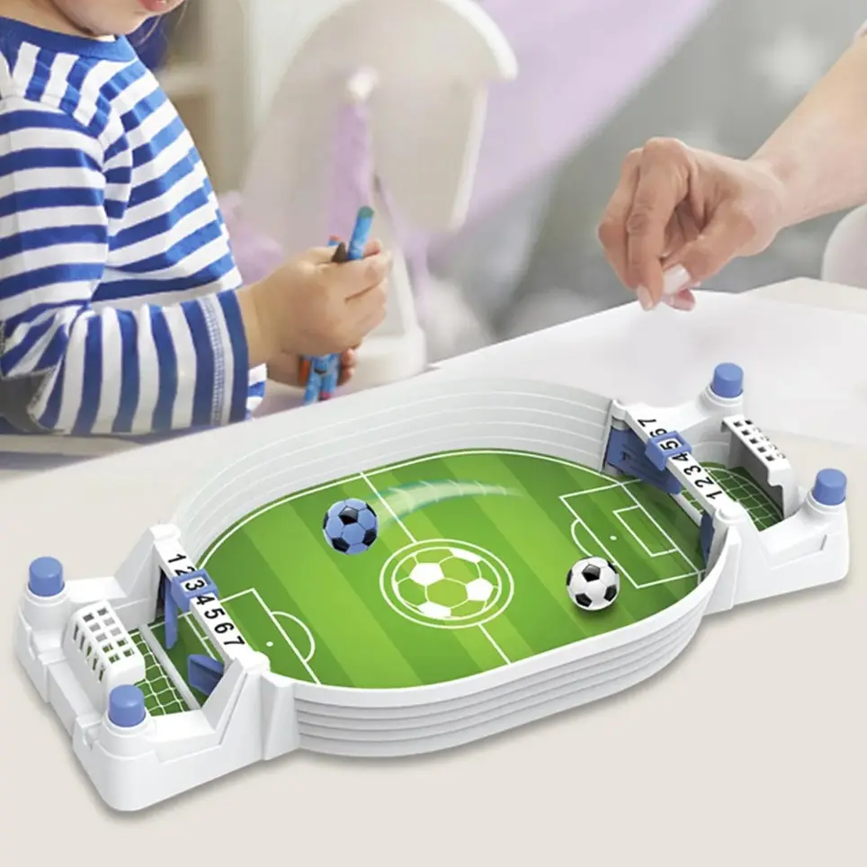 Futbolito de mesa portátil con campo verde, dos balones, marcadores numéricos del 1 al 7 y controles manuales, usado por un niño y un adulto.