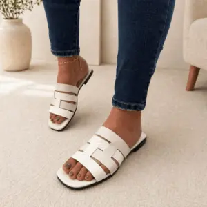 Sandalia plana casual blanca de mujer con tiras entrelazadas texturizadas, ideal para clima cálido.