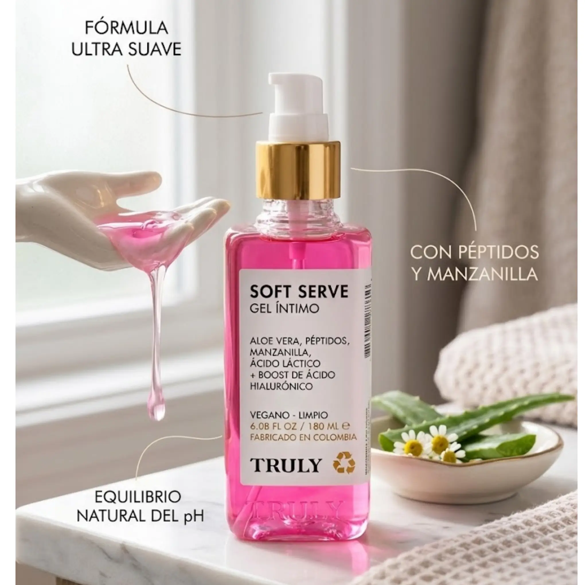 Gel íntimo rosa en botella dosificadora de 180 ml sobre mármol, con textura translúcida en una mano cerámica, aloe vera y manzanilla.