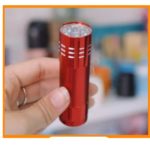 Linterna LED compacta de color rojo metálico con múltiples bombillos frontales, sostenida en la mano para mostrar su tamaño pequeño y diseño portátil.