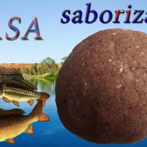 Masa para pescar moldeable color marrón texturizada junto a tres peces en un río con paisaje natural al fondo.