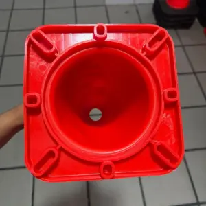Cono de PVC rojo para señalización vial visto desde la base superior cuadrada, mostrando su interior cónico y diseño estructural resistente.