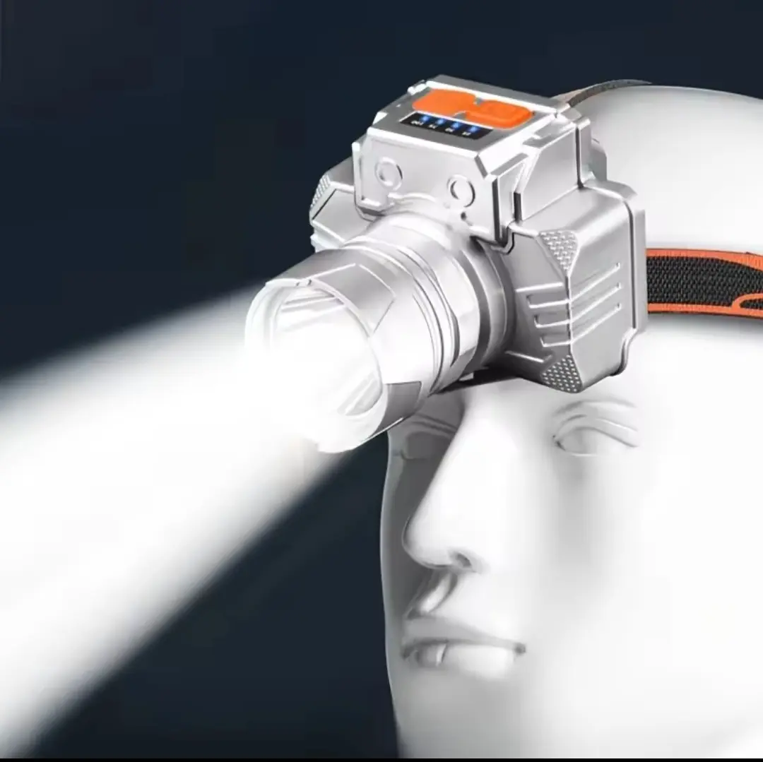 Linterna frontal LED recargable plateada y compacta colocada sobre cabeza de maniquí con potente haz de luz blanca y correa ajustable