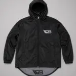 Chaqueta impermeable negra con capucha, cierre frontal, logotipo reflectivo en el pecho y dobladillo trasero extendido.