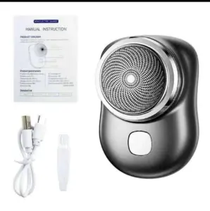 Mini afeitadora eléctrica portátil gris con lámina circular, incluye cable USB, cepillo limpiador y manual de instrucciones.