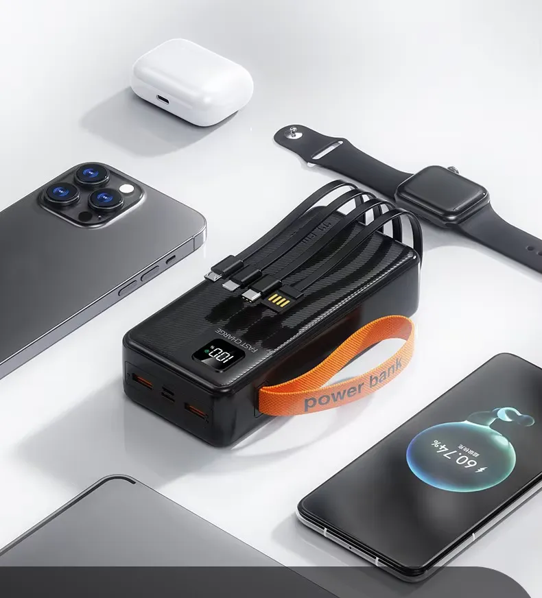 Power bank negro de carga rápida con pantalla LED digital, cuatro cables integrados, correa naranja y accesorios cargándose.