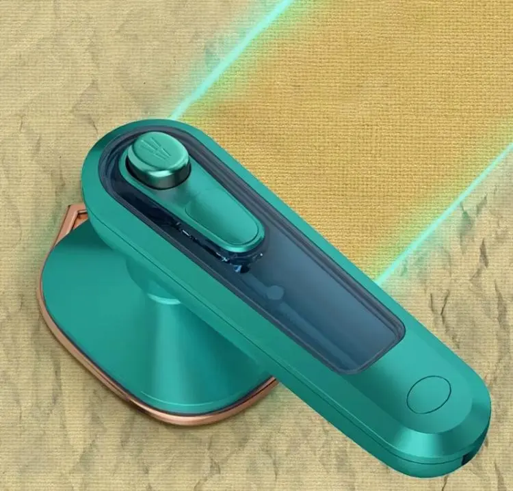 Plancha de vapor portátil color verde esmeralda con base metálica, diseñada para eliminar arrugas en telas sobre una superficie de textura rugosa.