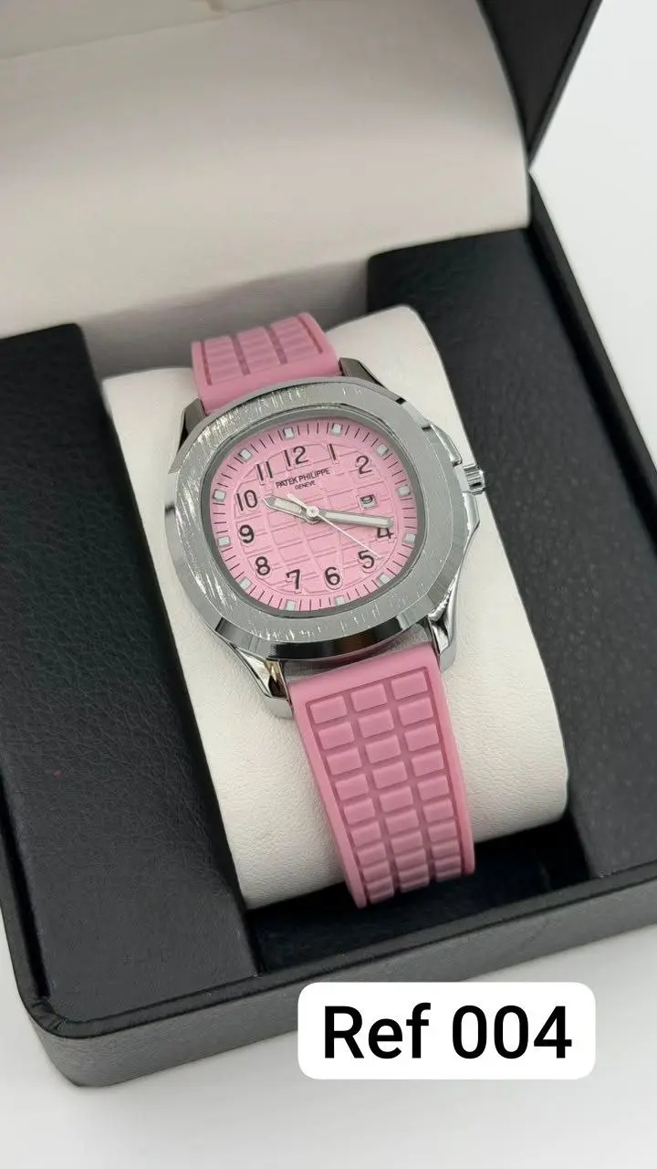 Reloj analógico unisex con pulso de silicona rosa texturizado, esfera rosada con números arábigos y caja plateada, dentro de estuche negro.