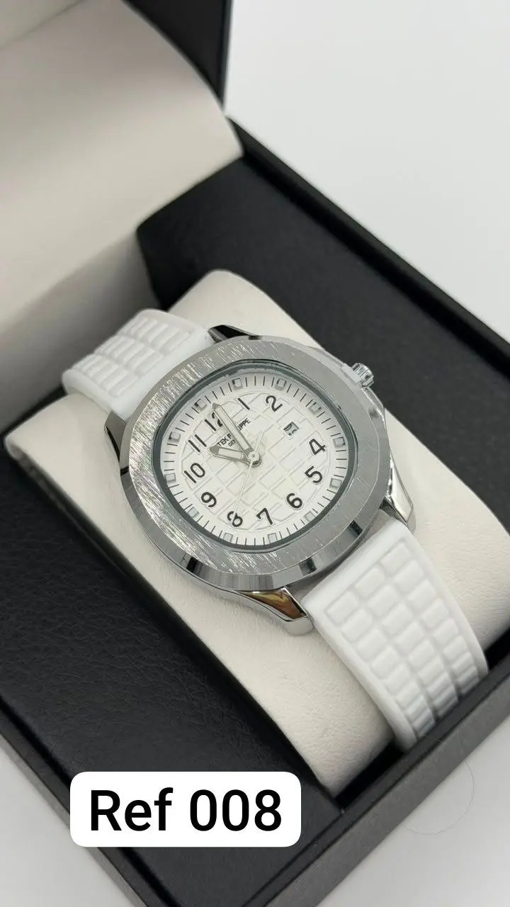 Reloj analógico unisex con pulso de silicona blanca y caja circular plateada texturizada, exhibido dentro de estuche negro.