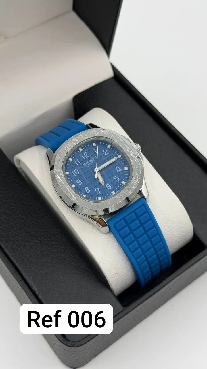 Reloj analógico unisex con pulso de silicona azul y esfera azul texturizada, presentado en estuche negro con almohadilla blanca.