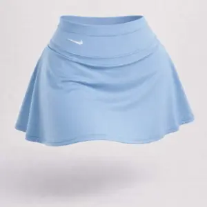 Falda short deportiva azul claro de tiro alto con pretina ancha y costuras horizontales, diseño acampanado y logo Nike blanco.