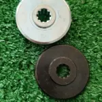 Dos placas de transmisión para guadaña Husqvarna 143RII con centro estriado, una en acabado metálico brillante y otra en color negro mate sobre césped.