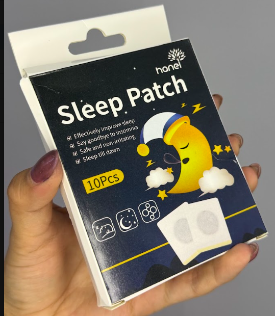 Caja de cartón azul oscuro de parches para dormir con de luna durmiendo y dos parches adhesivos cuadrados con círculo gris.