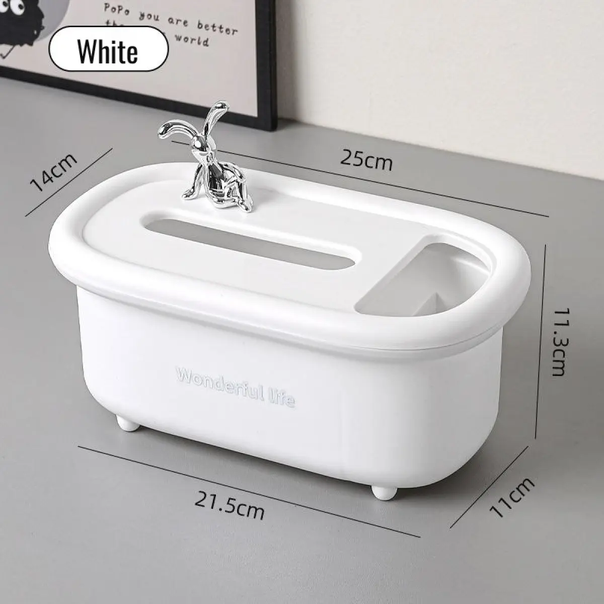 Cajonera organizadora multiusos blanca de polipropileno, de 25x14x11.3 cm, con ranura para pañuelos, compartimento auxiliar y figura decorativa plateada.