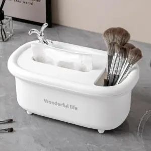 Organizador multiusos blanco de polipropileno con ranura para pañuelos y compartimento para brochas de maquillaje sobre superficie gris.