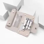 Set de manicura compacto en estuche rosa nude con tres cortauñas y cinco herramientas de acero inoxidable organizadas para viajes.