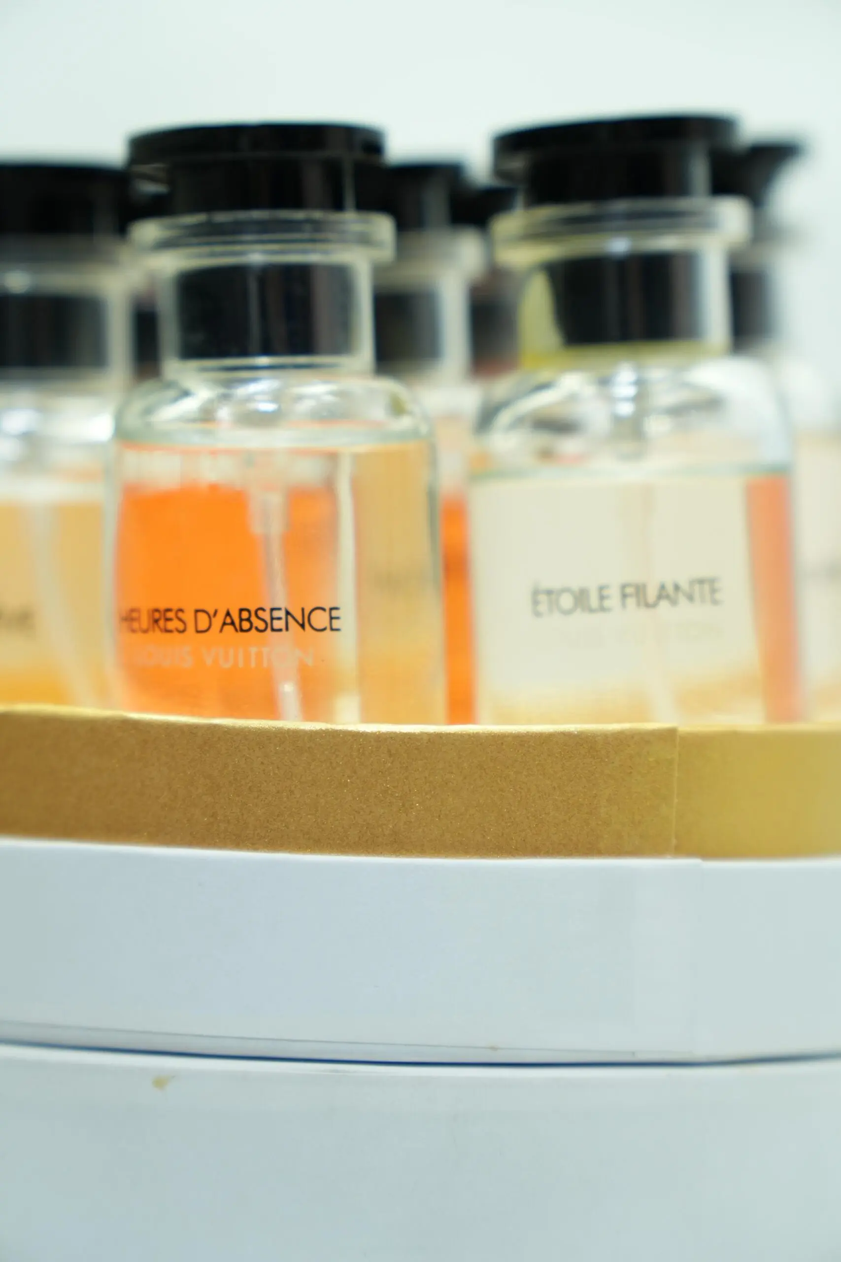 Estuche de lujo con botellas de perfume Louis Vuitton visibles, incluyendo las fragancias Heures d'Absence y Étoile Filante.