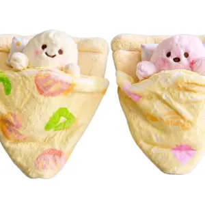 Set de dos peluches suaves en forma de porción de pizza con cojín, uno blanco y otro rosa, acostados con cobija decorativa estampada.