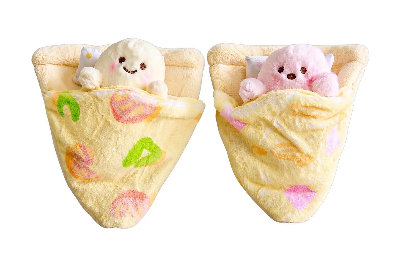 Set de dos peluches suaves en forma de porción de pizza con cojín, uno blanco y otro rosa, acostados con cobija decorativa estampada.